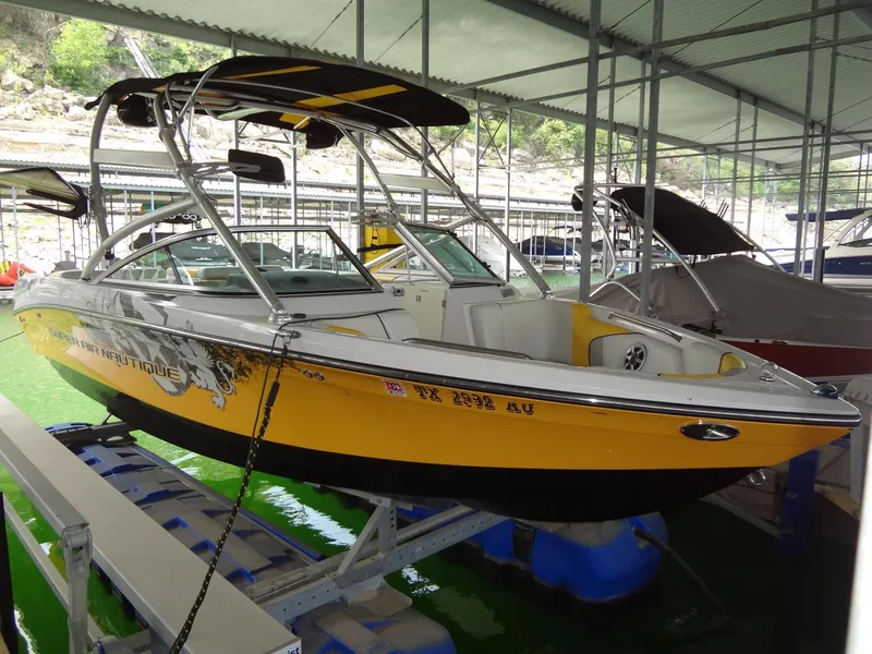 The Image of 2008 Correct Craft Super Air Nautique 230 boat on trailer, yellow and black design. - 0