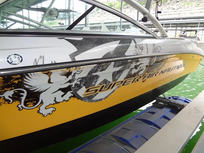 Slide: The Image of 2008 Correct Craft Super Air Nautique 230 boat, yellow with graphics, on a trailer. - 4