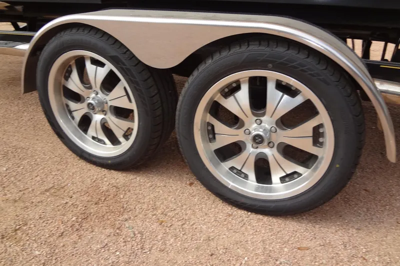 Slide: The Image of 2008 Correct Craft Super Air Nautique 230 trailer wheels on gravel surface. - 45