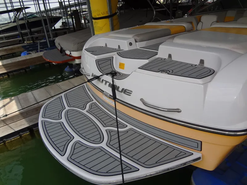 Slide: The Image of 2008 Correct Craft Super Air Nautique 230 in yellow, docked under a covered marina. - 8