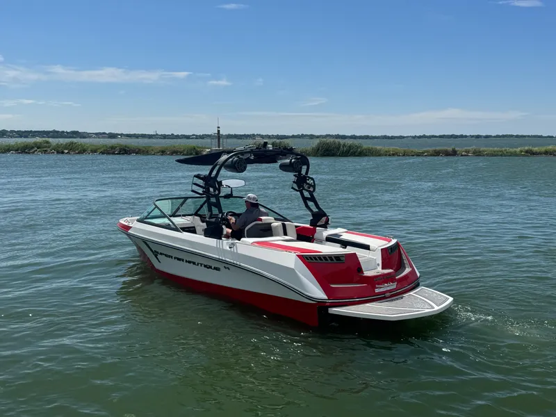 Slide: The Image of 2018 Nautique Super Air Nautique 210 boat on a lake under clear skies. - 5