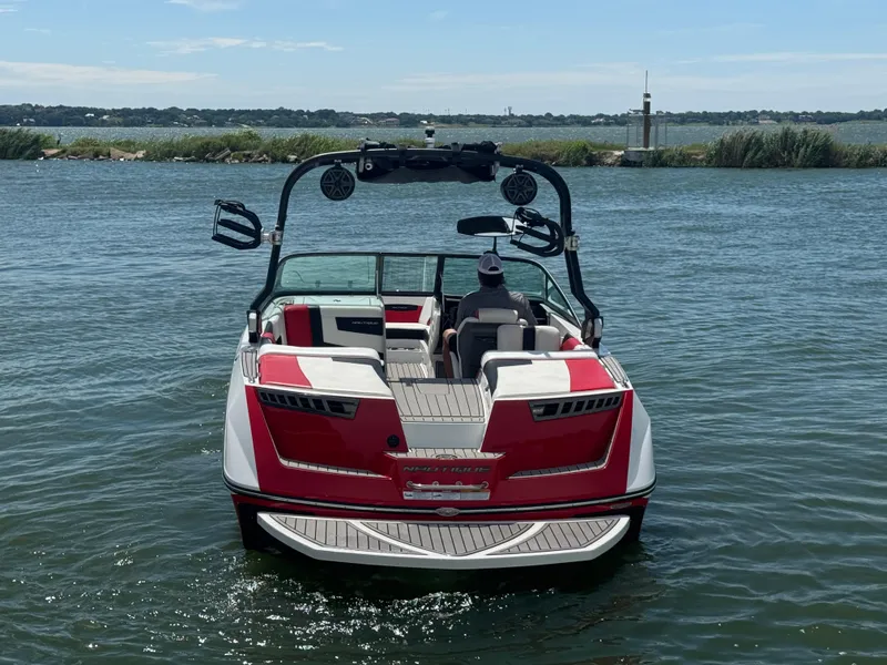 Slide: The Image of 2018 Nautique Super Air Nautique 210 boat on water, rear view, sunny day. - 6