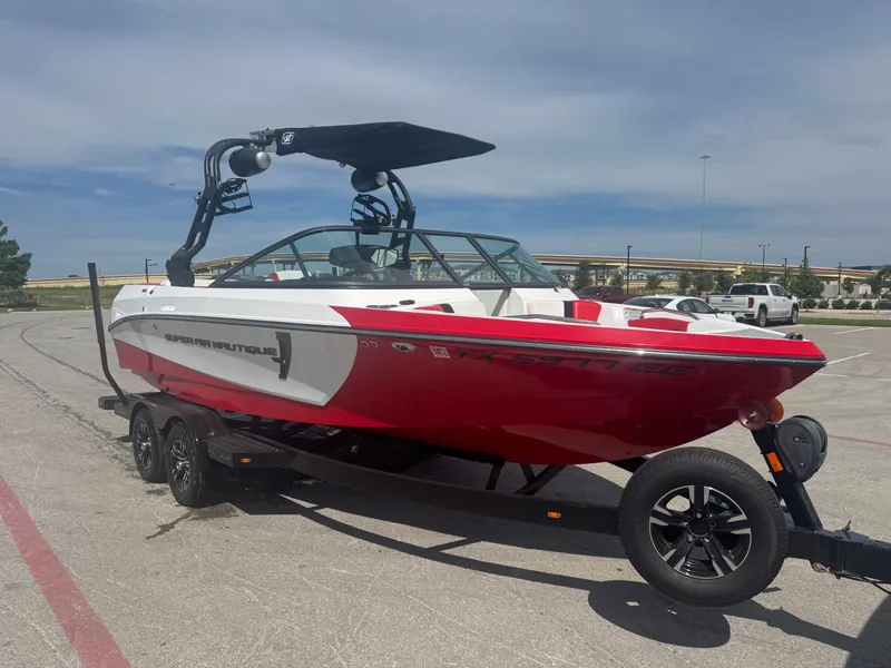 Slide: The Image of 2018 Nautique Super Air Nautique 210 boat in red and white on a trailer. - 7