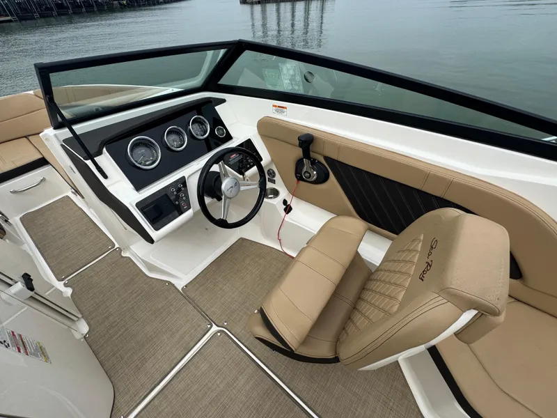 Slide: The Image of 2019 Sea Ray SPX 230 boat interior with beige seating and modern dashboard. - 10