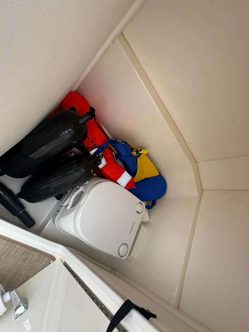 Slide: The Image of 2019 Sea Ray SPX 230 storage area with life jackets and fenders. - 22