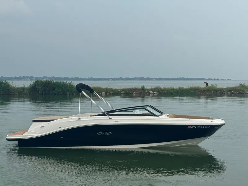 Slide: The Image of 2019 Sea Ray SPX 230 boat on calm water with distant shoreline. - 3
