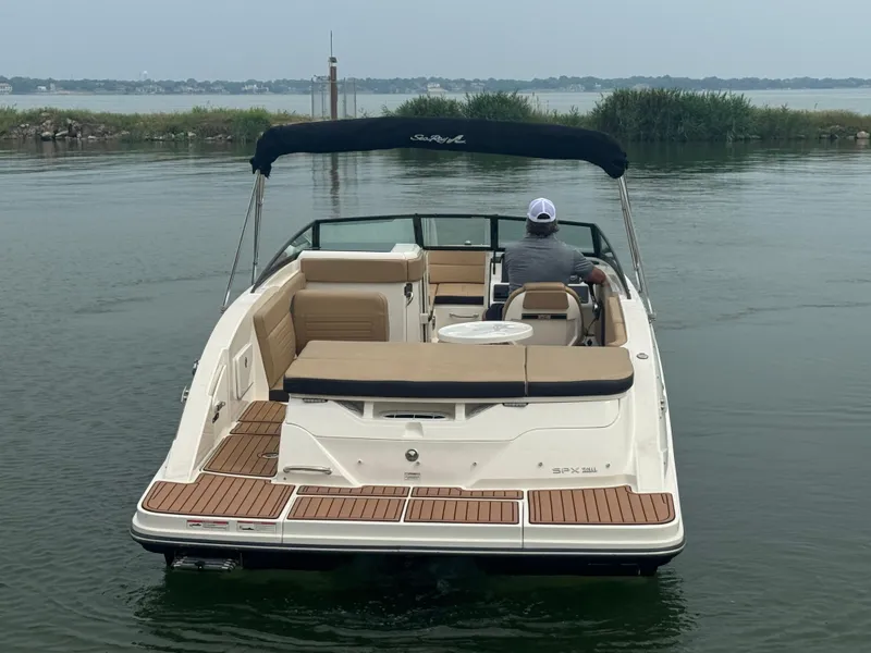Slide: The Image of 2019 Sea Ray SPX 230 boat on calm water, rear view with canopy and seating. - 4
