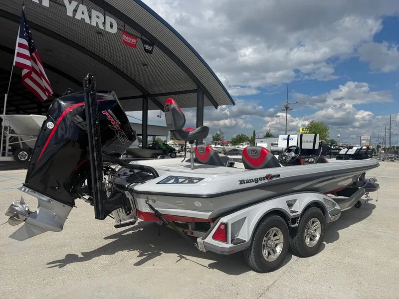 Slide: The Image of 2021 Ranger Z521L Intracoastal boat on trailer, parked outdoors under cloudy sky. - 2