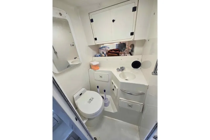 Slide: The Image of 1998 Hydra-Sports 3100 SF boat bathroom with toilet, sink, and storage cabinets. - 8