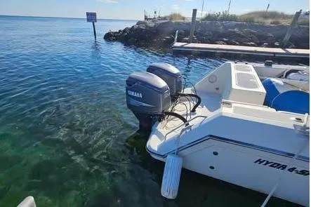 Slide: The Image of 1998 Hydra-Sports 3100 SF boat with Yamaha engines docked in clear water. - 9