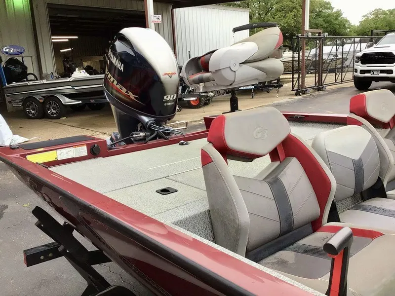 Slide: The Image of 2020 G3 1710 SPORTSMAN boat with Yamaha motor, red and gray seating, parked outdoors. - 17