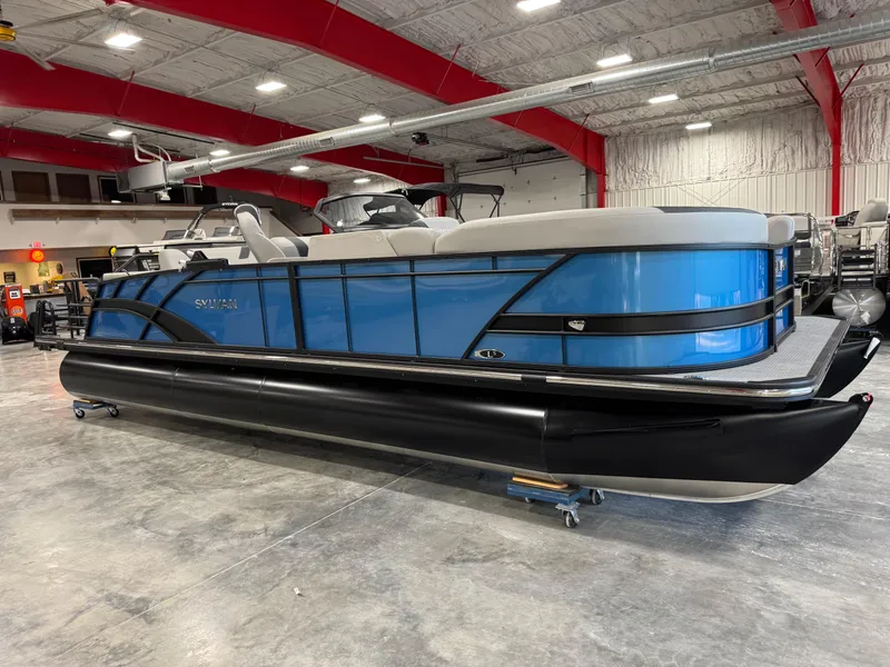 Slide: The Image of 2025 Sylvan L5 CLZ DH pontoon boat in a showroom with red ceiling beams. - 7
