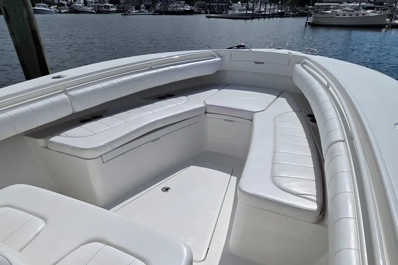 Slide: The Image of 2014 Regulator 28 Forward Seating boat with spacious white seating area, docked by the water. - 10