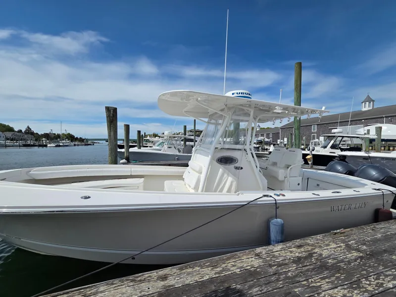Slide: The Image of 2014 Regulator 28 Forward Seating boat docked at a marina under a clear blue sky. - 3