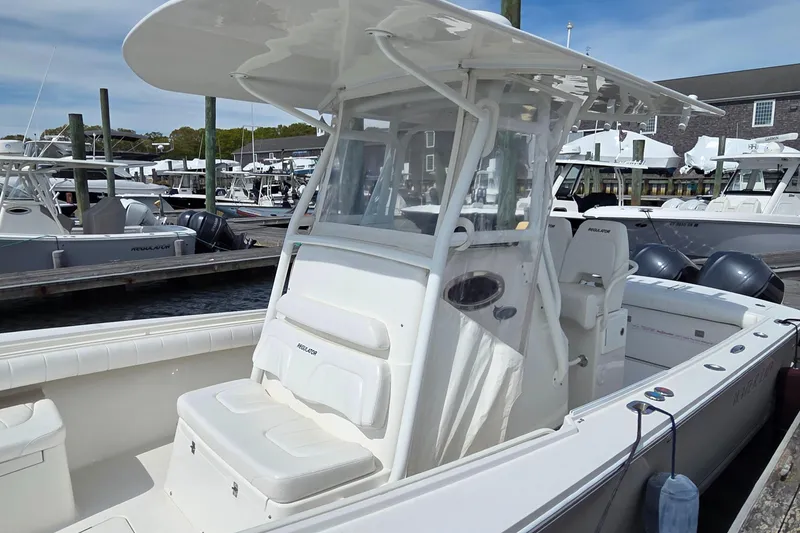 Slide: The Image of 2014 Regulator 28 Forward Seating boat docked at marina, featuring spacious seating and dual engines. - 4