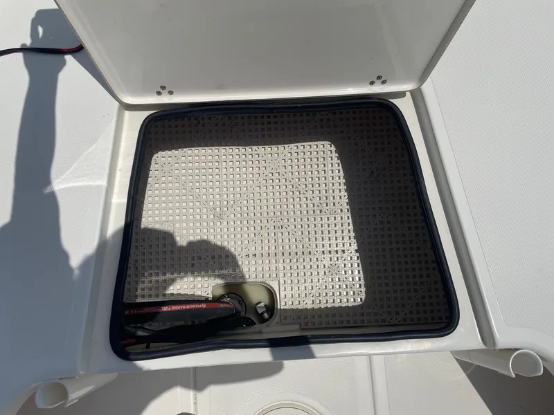 Slide: The Image of Open storage compartment on a 2013 Mako 18lts boat, showing interior details. - 13