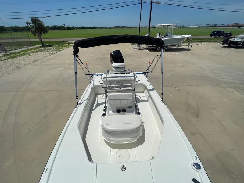 Slide: The Image of 2013 Mako 18lts boat with bimini top, parked on concrete near grassy area. - 16