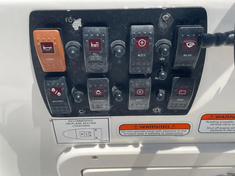 Slide: The Image of Control panel of a 2013 Mako 18lts boat with various switches and warning labels. - 21