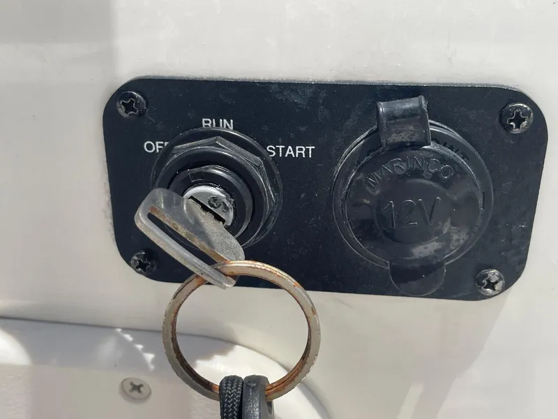 Slide: The Image of Key ignition and 12V outlet on 2013 Mako 18lts boat dashboard. - 22