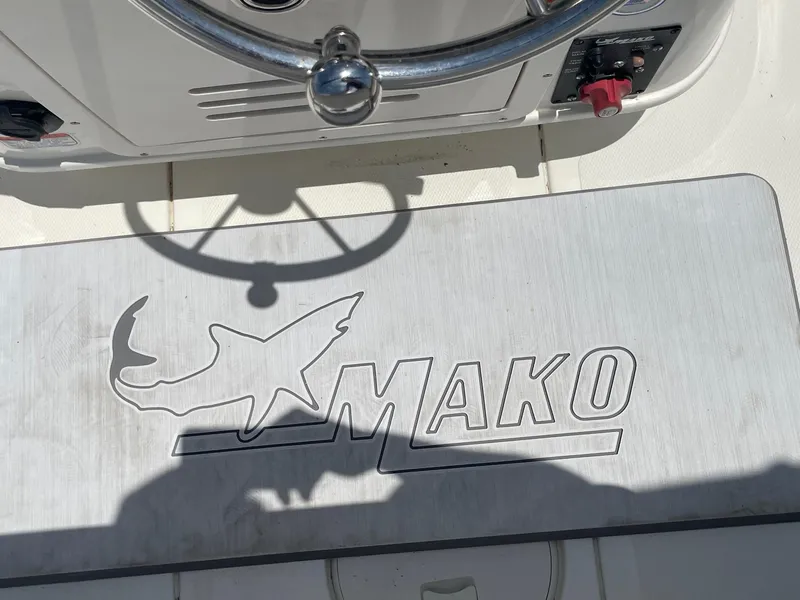 Slide: The Image of 2013 Mako 18lts boat dashboard with steering wheel and logo. - 24