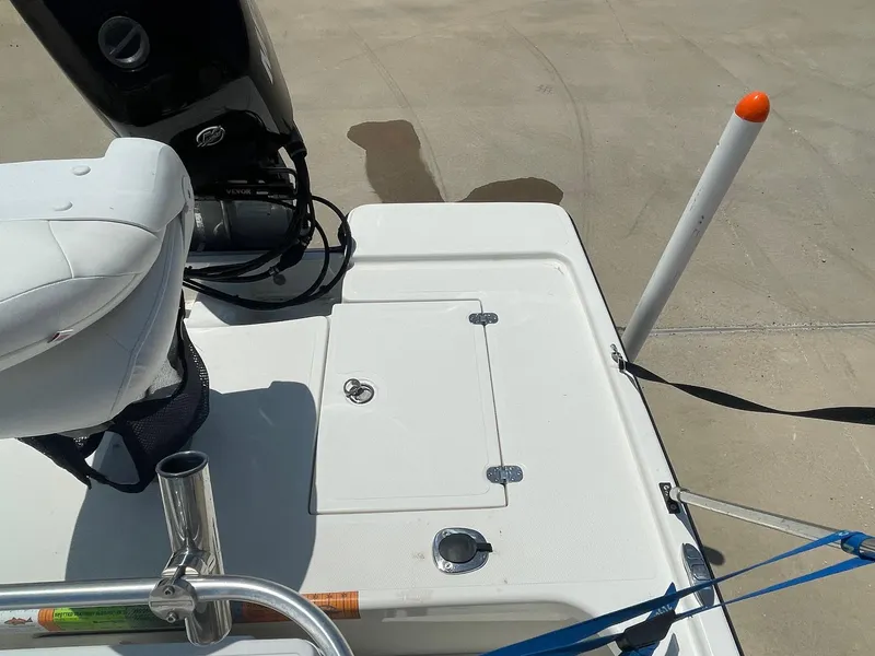 Slide: The Image of 2013 Mako 18lts boat deck with seat and motor, docked on concrete surface. - 26