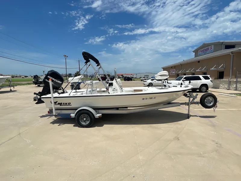 Slide: The Image of 2013 Mako 18lts boat on trailer in parking lot, clear sky background. - 7