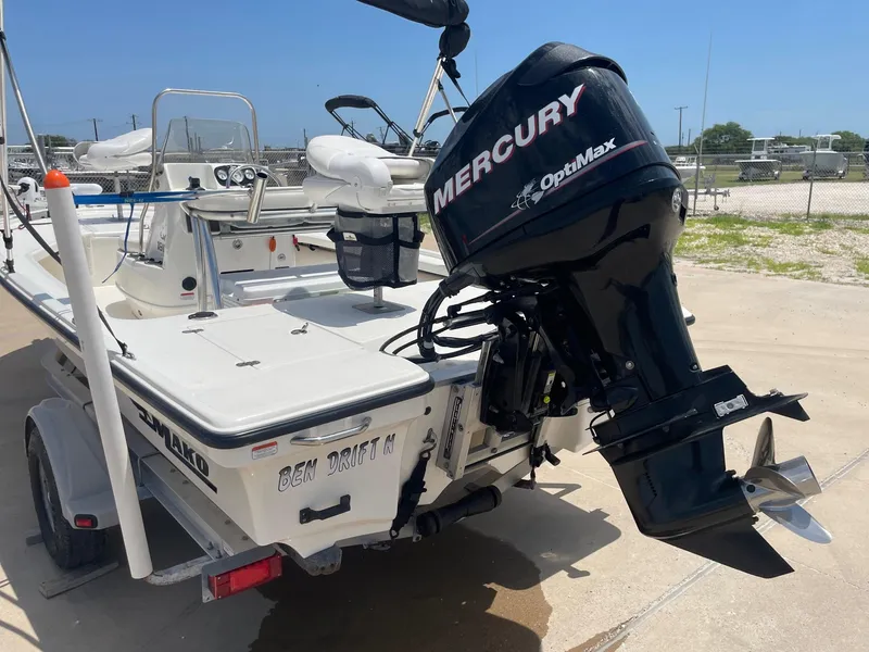 Slide: The Image of 2013 Mako 18lts boat with Mercury OptiMax engine, parked on a trailer. - 9