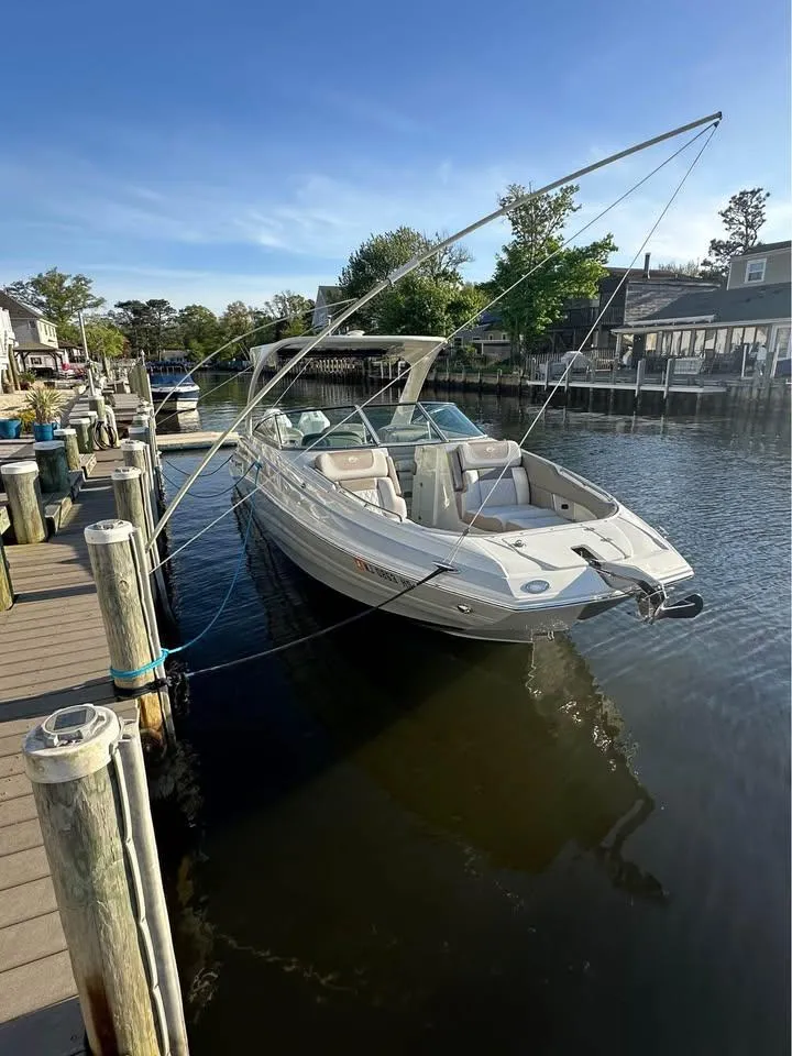 Slide: The Image of 2022 Crownline Eclipse E305 XS boat docked in a serene marina setting. - 3