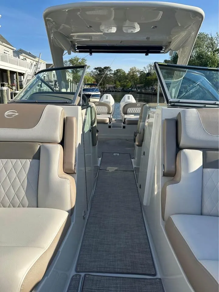 Slide: The Image of 2022 Crownline Eclipse E305 XS boat interior with luxurious seating and open deck. - 6