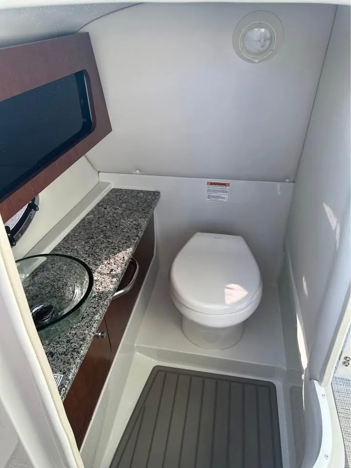 Slide: The Image of 2022 Crownline Eclipse E305 XS boat bathroom with modern sink and granite countertop. - 7
