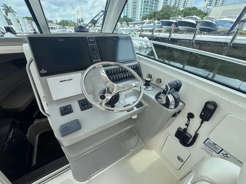 Slide: The Image of 2015 Boston Whaler 345 Conquest helm with modern controls and dual screens at marina. - 15