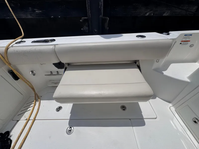 Slide: The Image of 2015 Boston Whaler 345 Conquest boat seat with white upholstery and deck view. - 18