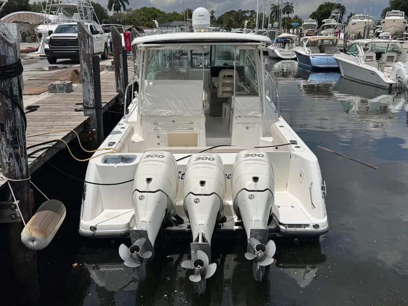 Slide: The Image of 2015 Boston Whaler 345 Conquest with triple 300 HP engines docked at marina. - 2