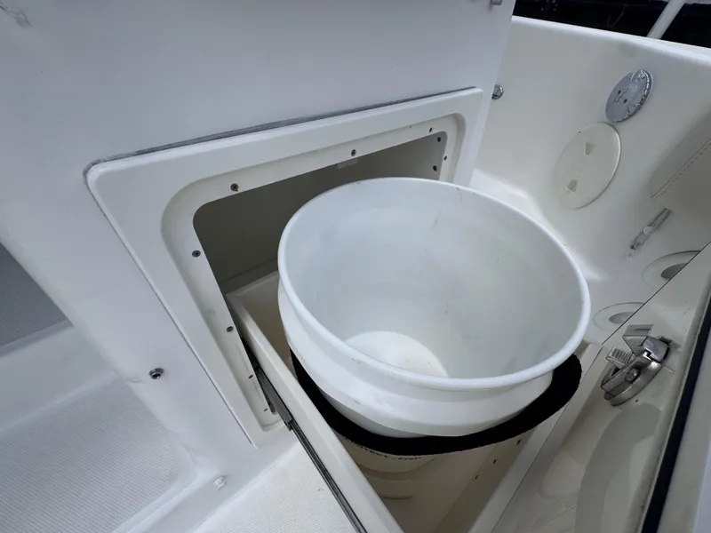 Slide: The Image of 2015 Boston Whaler 345 Conquest storage compartment with white bucket. - 21