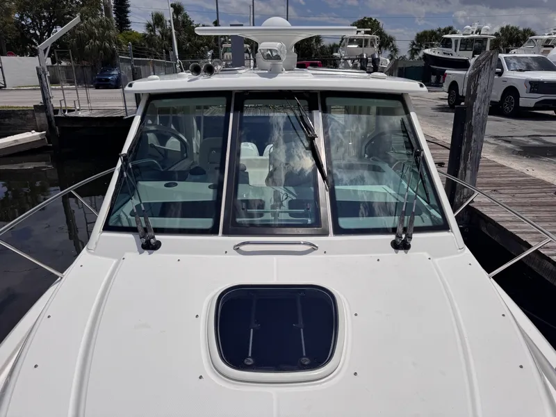 Slide: The Image of 2015 Boston Whaler 345 Conquest boat docked, front view with windshield and hatch. - 31