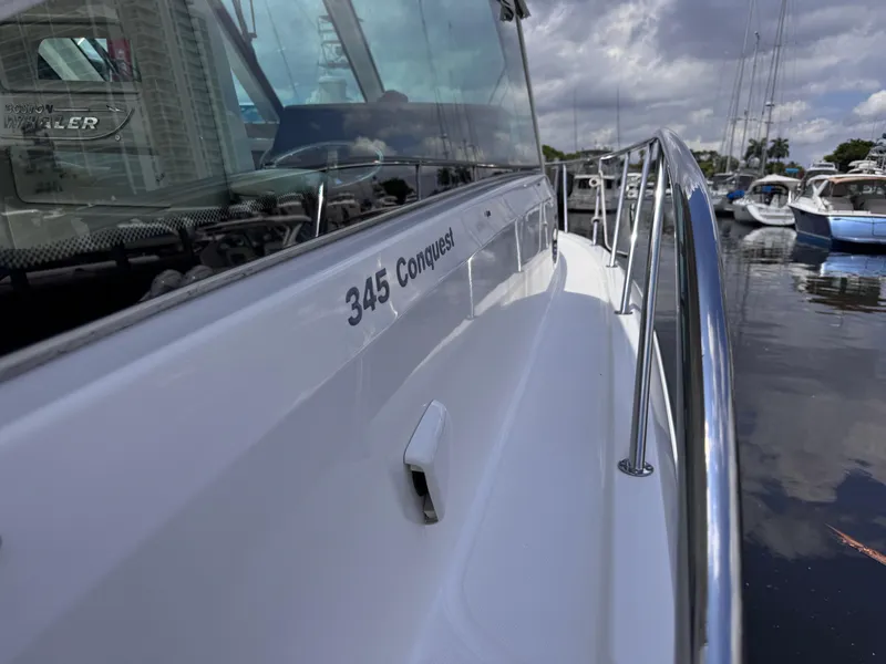 Slide: The Image of 2015 Boston Whaler 345 Conquest boat docked, showcasing sleek design and railing. - 36