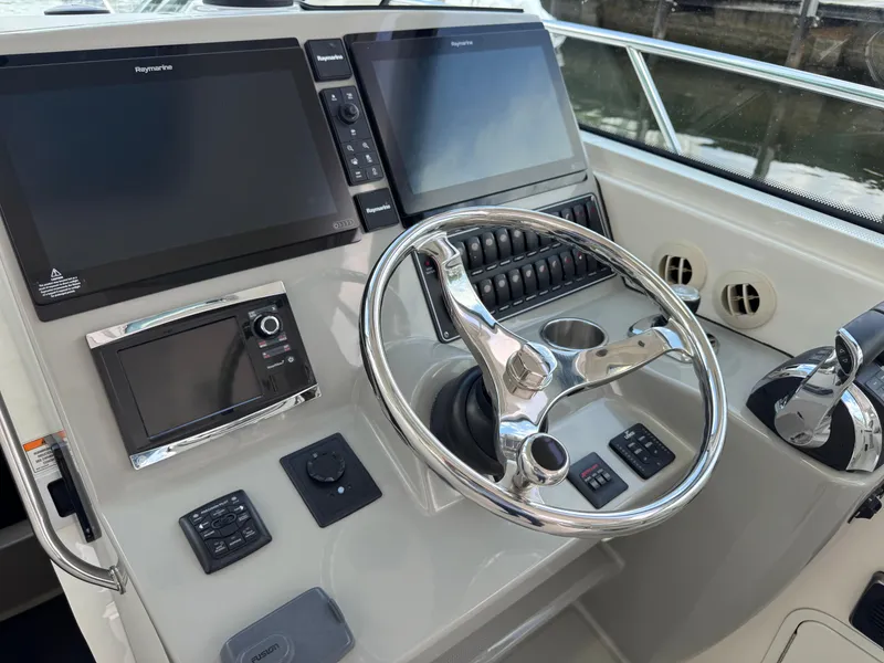 Slide: The Image of Control panel of a 2015 Boston Whaler 345 Conquest boat with steering wheel and navigation screens. - 37