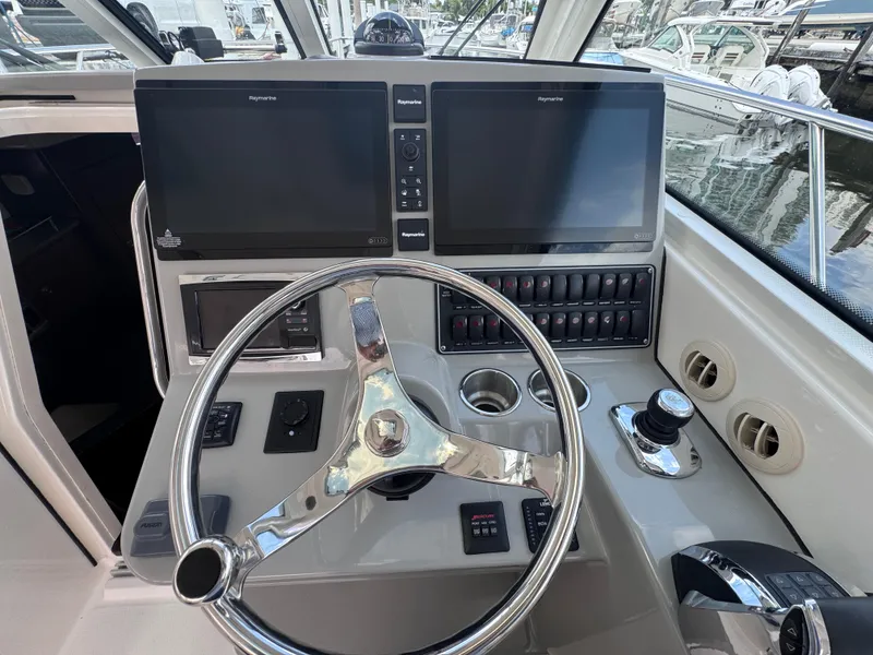 Slide: The Image of 2015 Boston Whaler 345 Conquest helm with dual screens and steering wheel. - 38