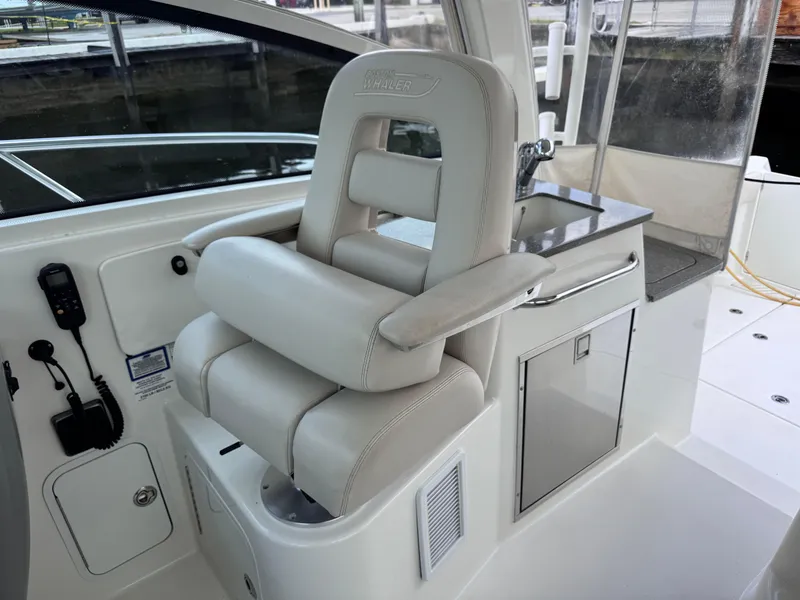 Slide: The Image of Captain's chair on 2015 Boston Whaler 345 Conquest boat, featuring sleek design and controls. - 44