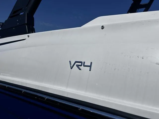 Slide: The Image of 2023 Bayliner VR4 Bowrider boat side view with logo detail. - 2