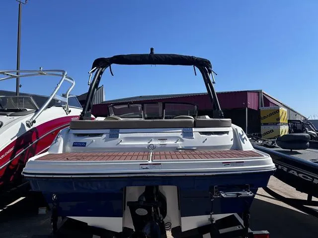 Slide: The Image of 2023 Bayliner VR4 Bowrider boat with sleek design, docked outdoors under clear blue sky. - 4