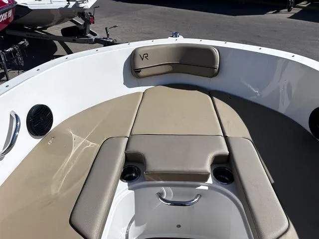 Slide: The Image of 2023 Bayliner VR4 Bowrider boat interior with beige seating and cup holders. - 8