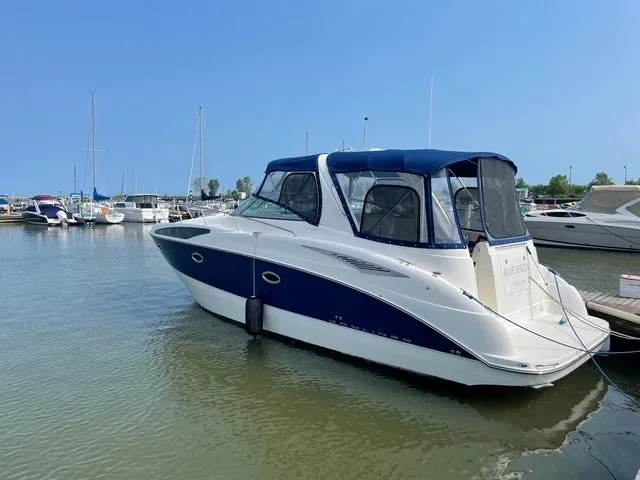 Slide: The Image of 2007 Bayliner 325 boat docked in a marina under clear blue skies. - 2