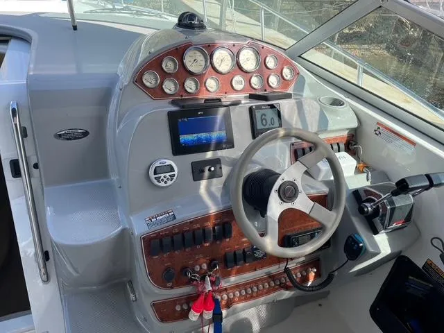 Slide: The Image of 2007 Bayliner 325 boat dashboard with gauges, steering wheel, and control panel. - 3