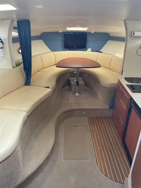 Slide: The Image of Interior of 2007 Bayliner 325 boat with seating, table, and kitchenette. - 4