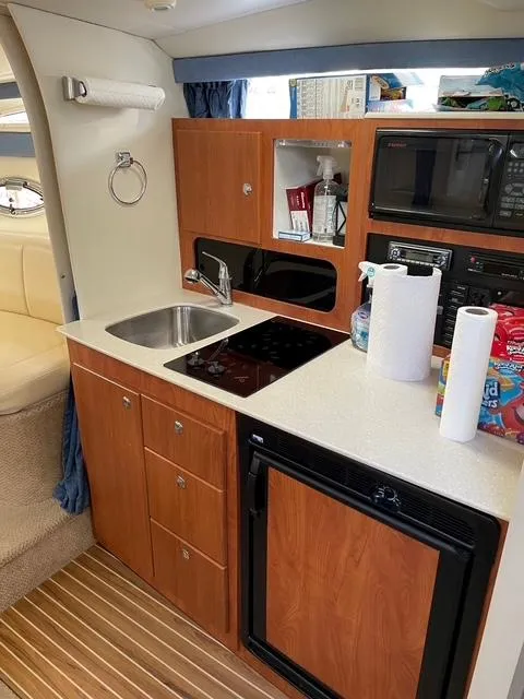 Slide: The Image of 2007 Bayliner 325 yacht kitchen with sink, stove, microwave, and fridge. - 5