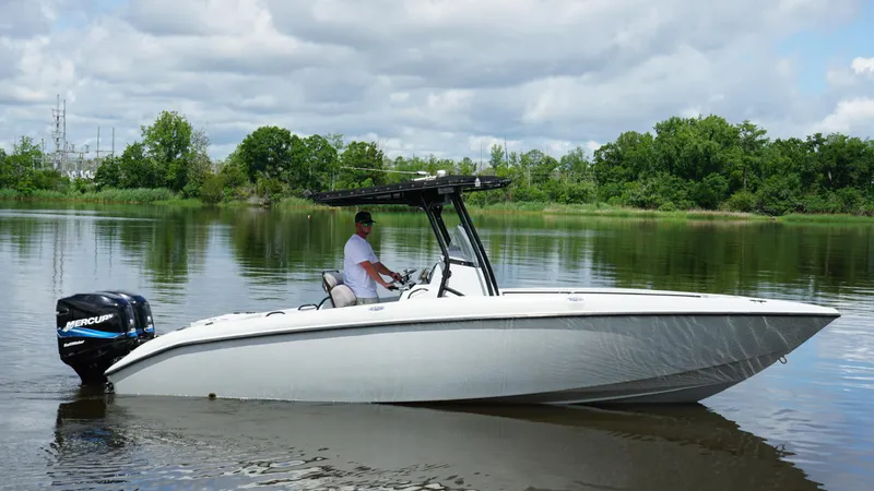 Slide: The Image of 2004 Baja 250 Sportfish boat on calm water with lush green background. - 18