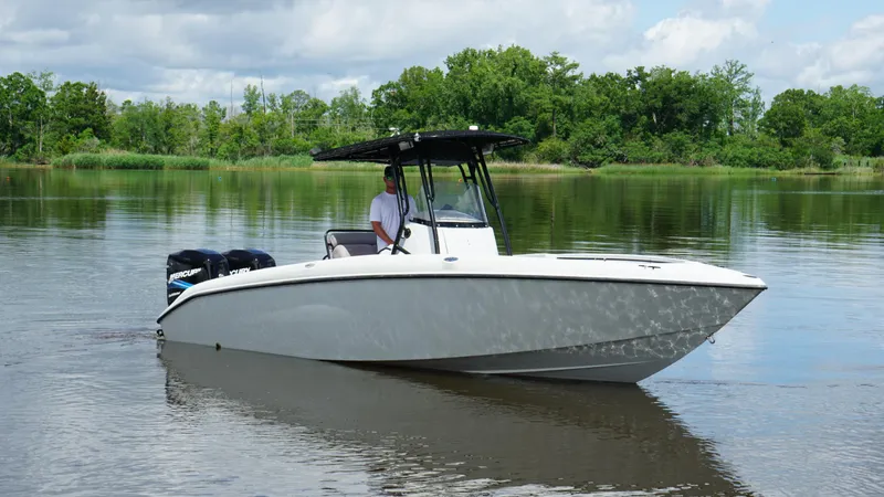 Slide: The Image of 2004 Baja 250 Sportfish boat on calm water with lush green background. - 19