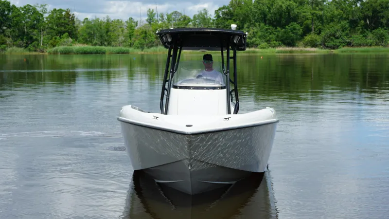 Slide: The Image of 2004 Baja 250 Sportfish boat on calm water, surrounded by lush greenery. - 2