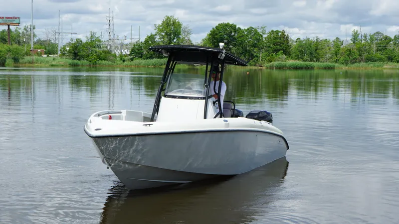 Slide: The Image of 2004 Baja 250 Sportfish boat on calm water, surrounded by lush greenery. - 21